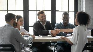 Client and chief of a marketing agency shaking hands.