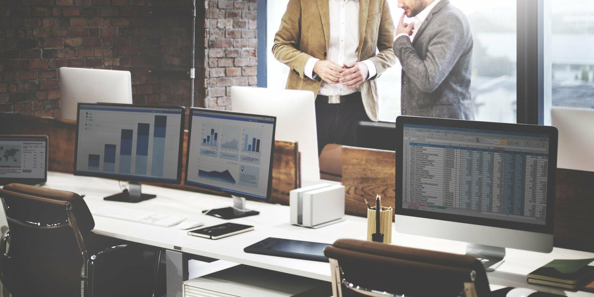 Modern IT office with multiple computer workstations displaying data.