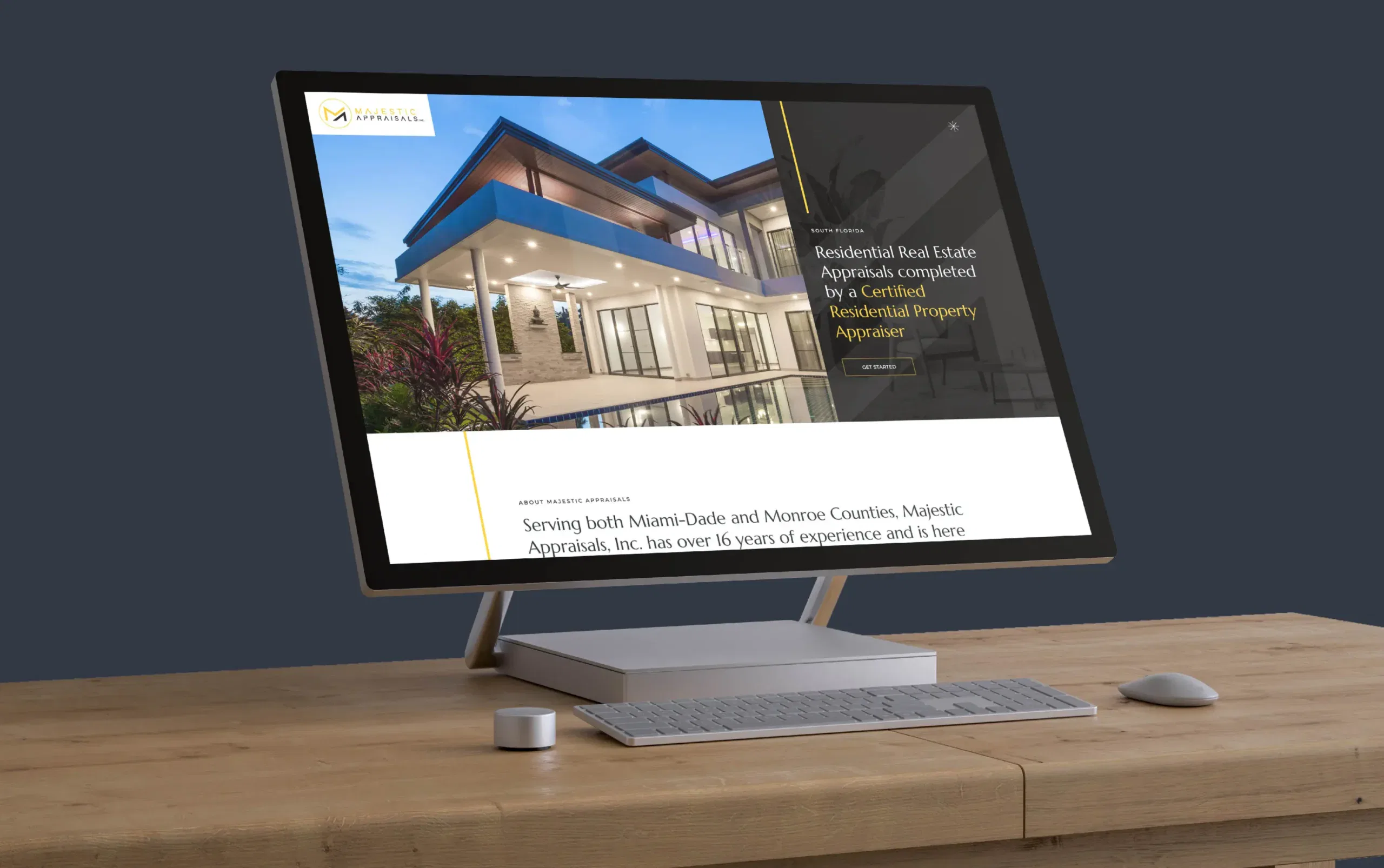 Computer monitor on wooden desk displaying a real estate website with a modern house image.