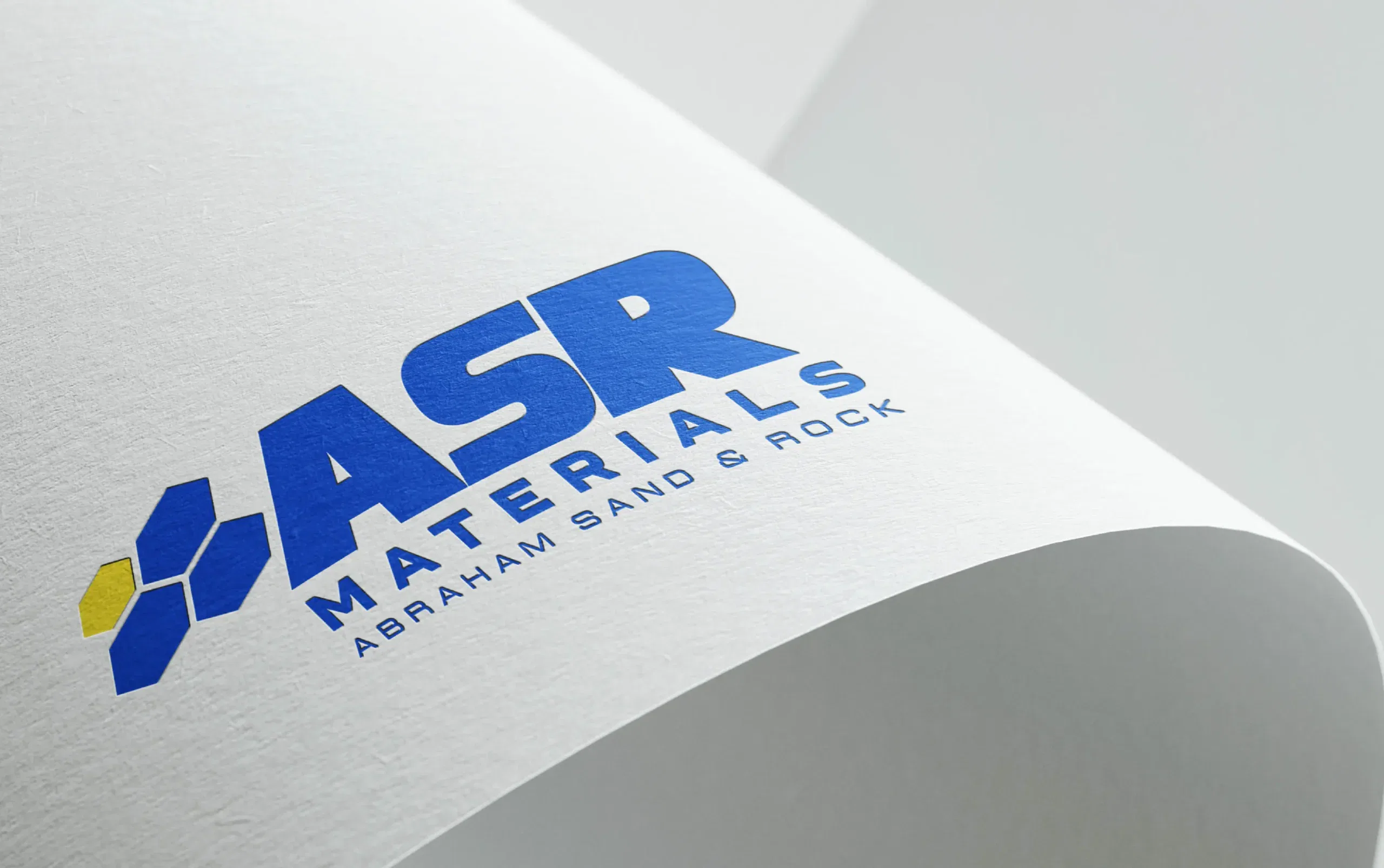 ASR Materials logo on a white paper surface, showcasing bold blue lettering and geometric design.