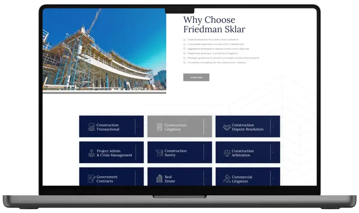 Laptop displaying a construction company's website with modern design and navigation menu.