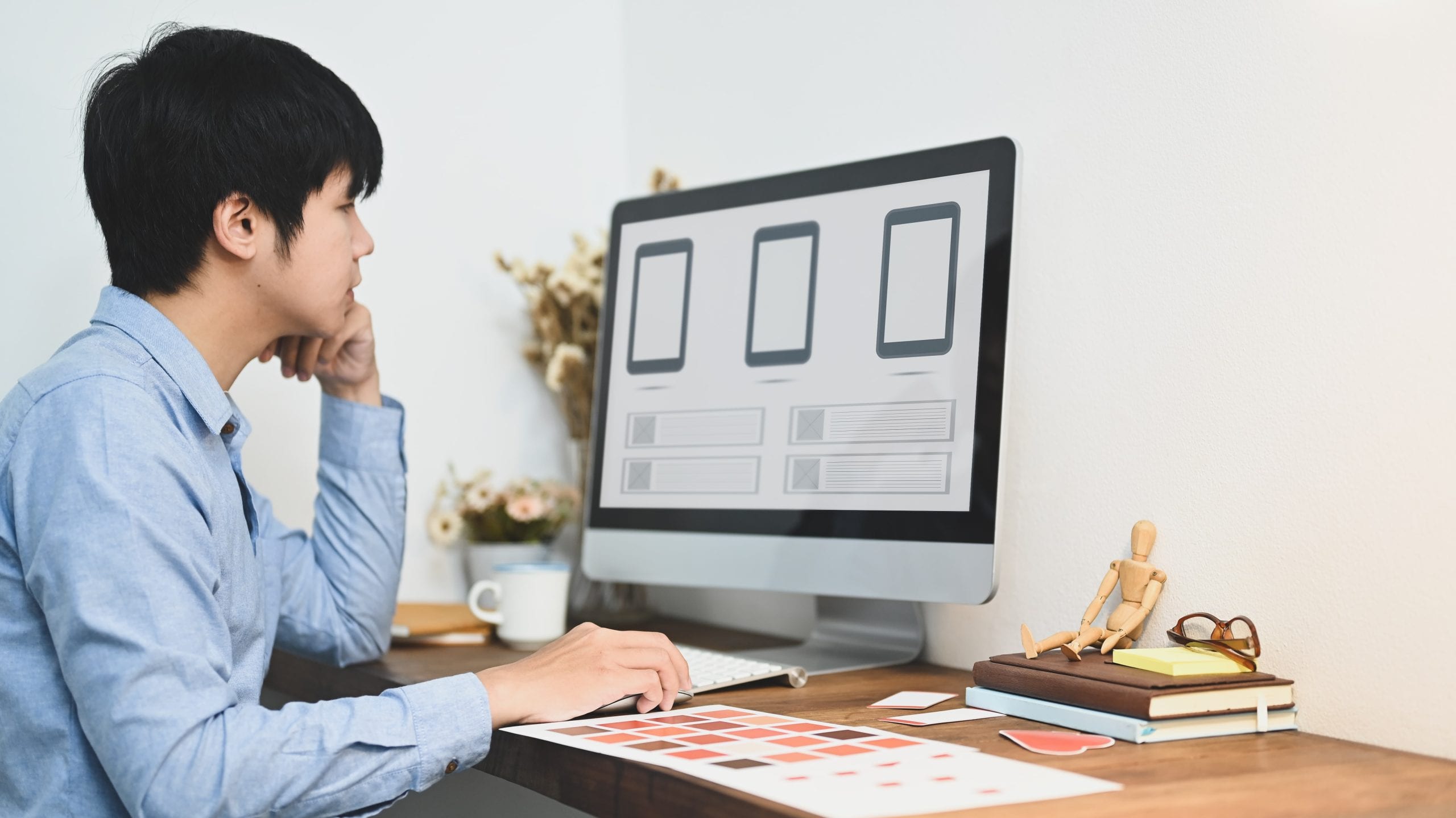 Graphic designer working on a computer in a minimalistic office setting.