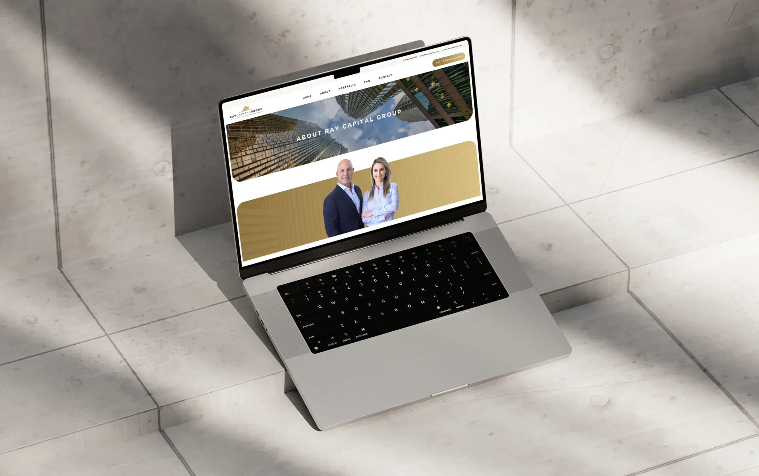 Laptop displaying a professional team website on a tiled floor.