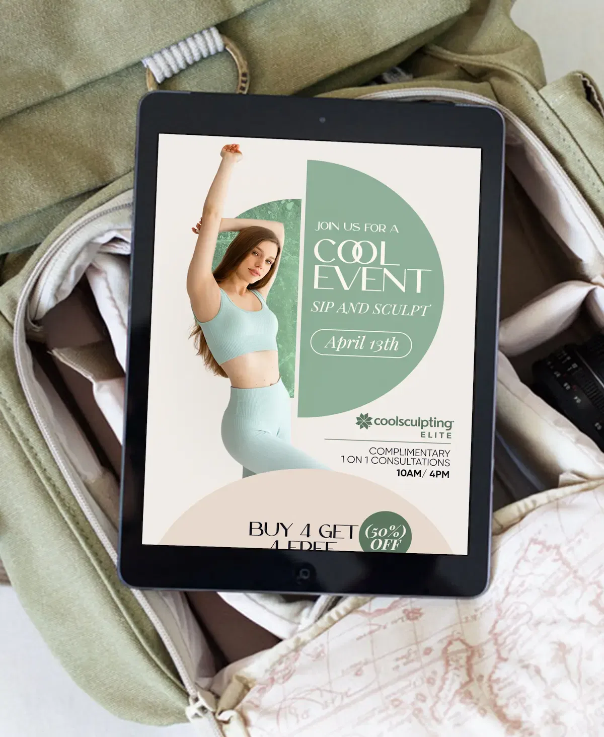 Tablet displaying ad for a fitness and beauty event on a packed beige suitcase.