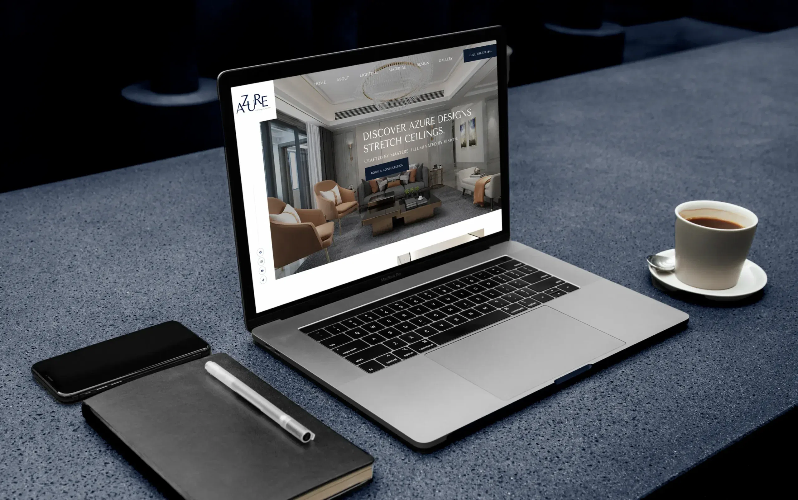 A sleek laptop displaying a modern website beside a notebook and coffee, set on a dark tabletop.