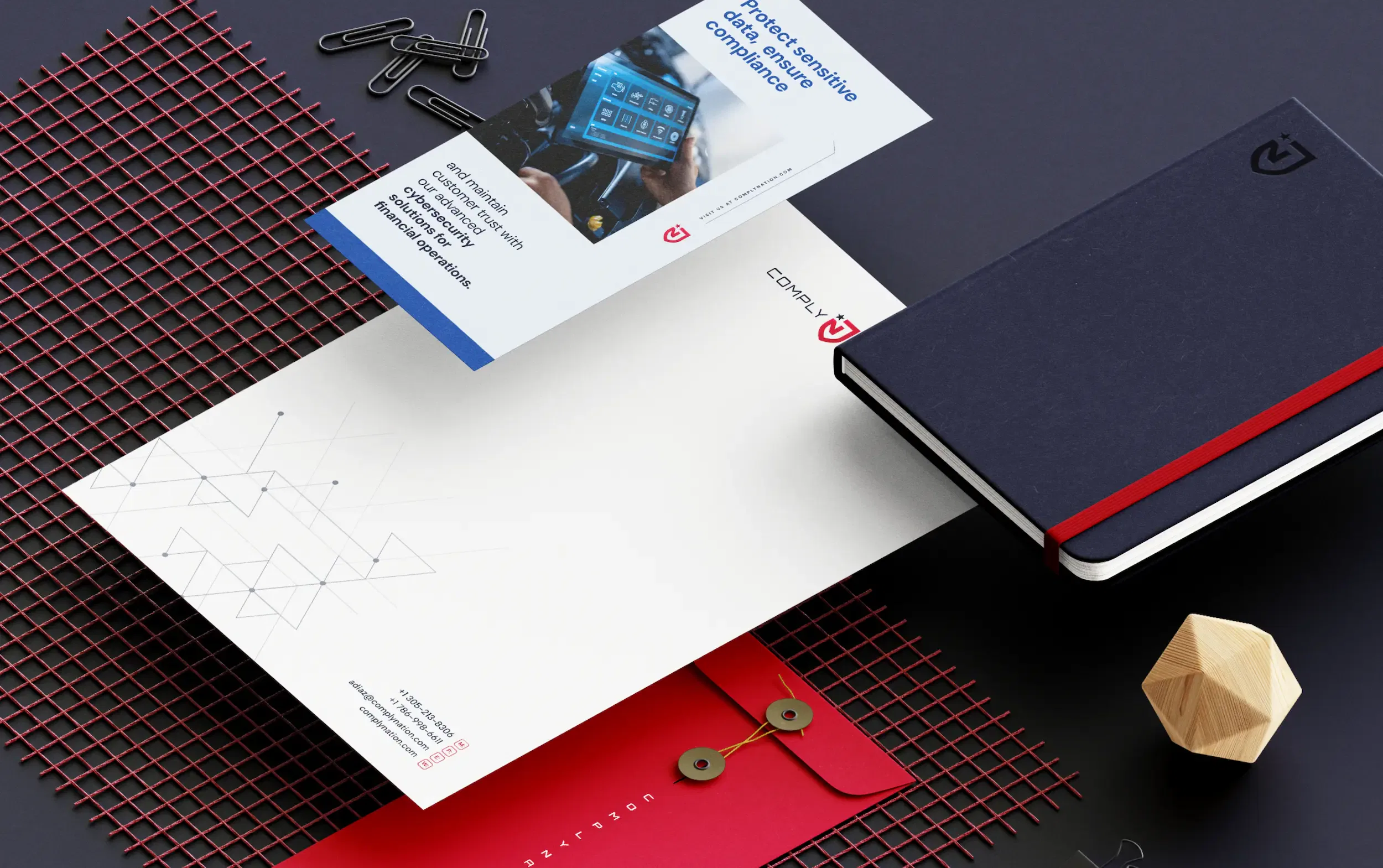 Office supplies and stationery arrangement on a desk with notebook, pamphlet, and geometric decor.