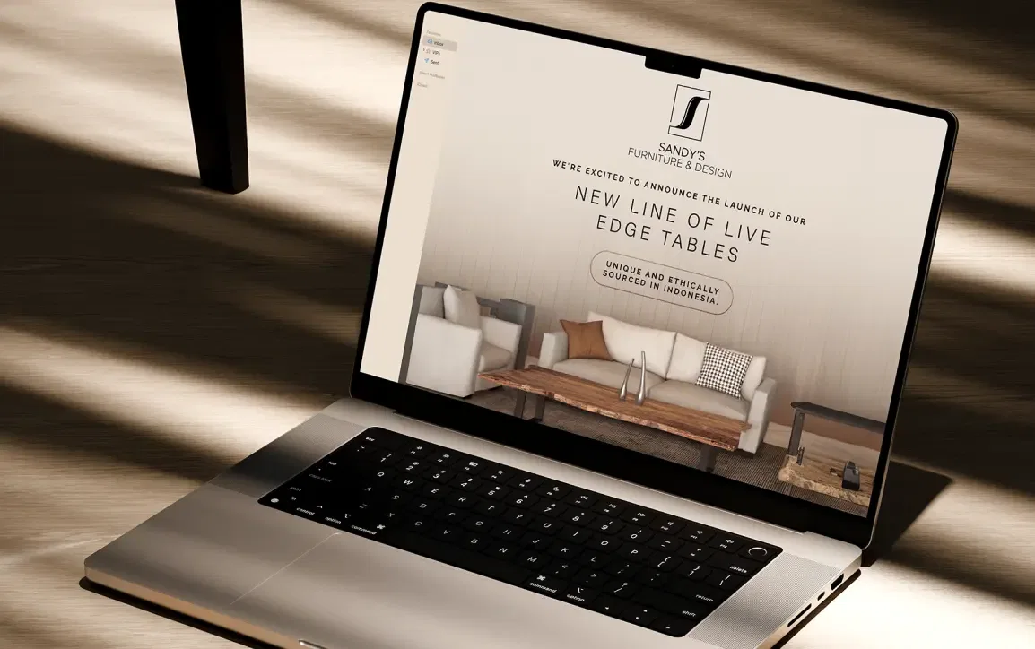 Laptop displaying a luxury furniture website with a focus on live edge tables.