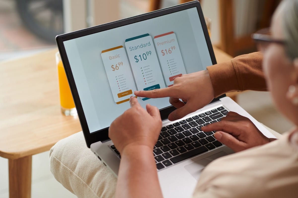 Two people discussing service subscription plans displayed on a laptop screen.