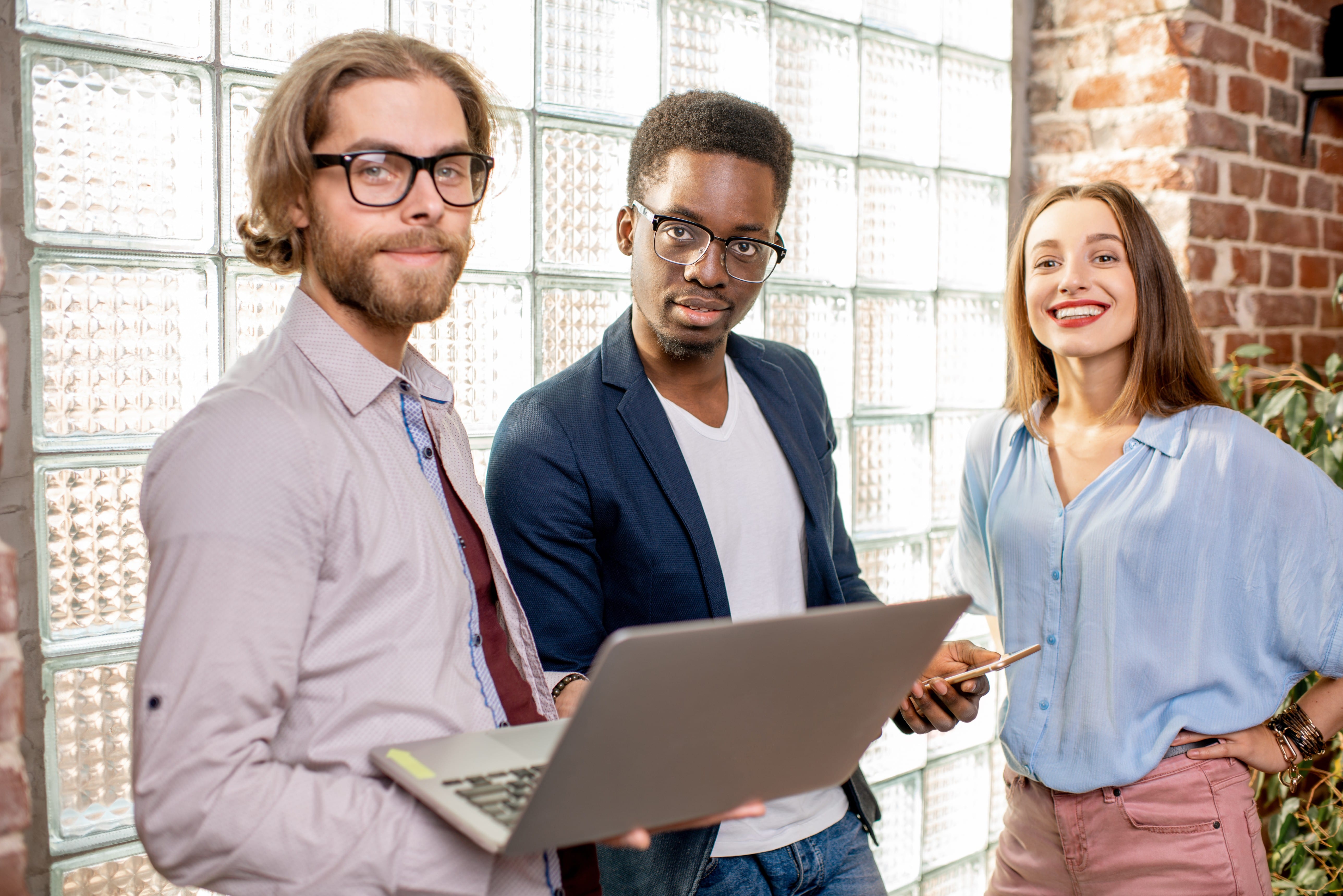 Three professionals collaborating with laptop